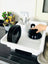 White dish drainer with black dishes on a kitchen counter