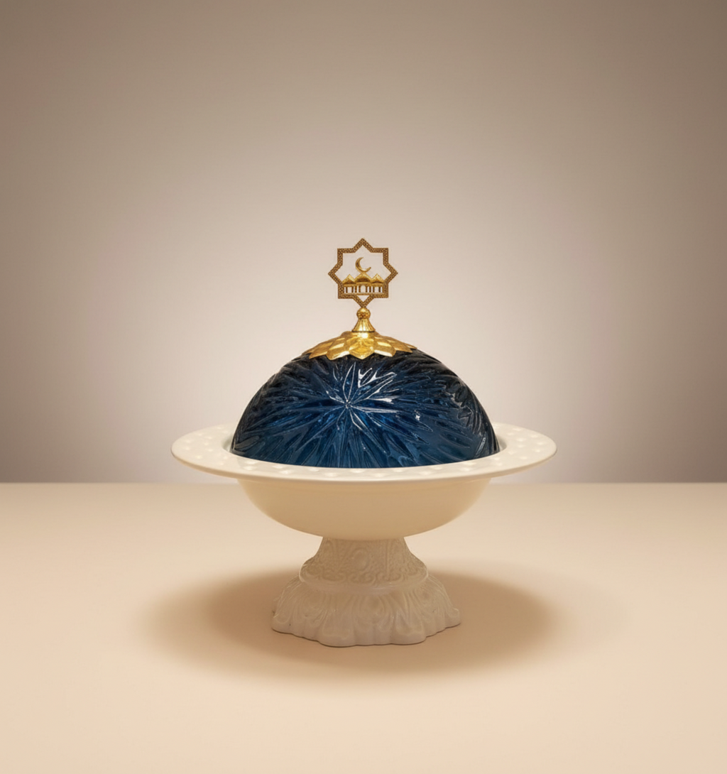 Decorative dish with blue glass dome and gold finial on a beige background