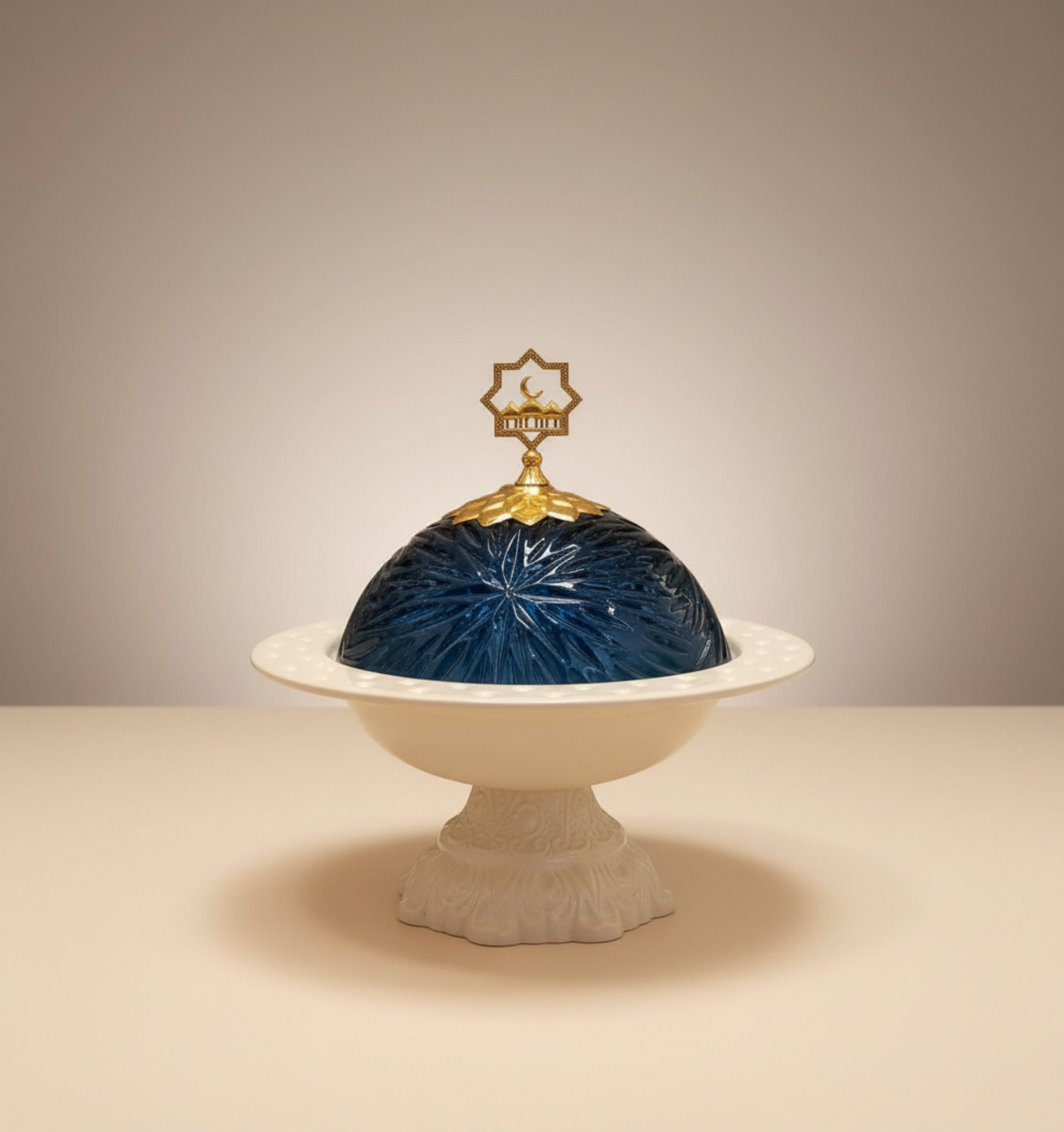 Decorative dish with blue glass dome and gold finial on a beige background